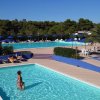Una piscina esterna con persone che nuotano e rilassano.