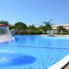 Piscina con fontana e vegetazione tropicale sullo sfondo.